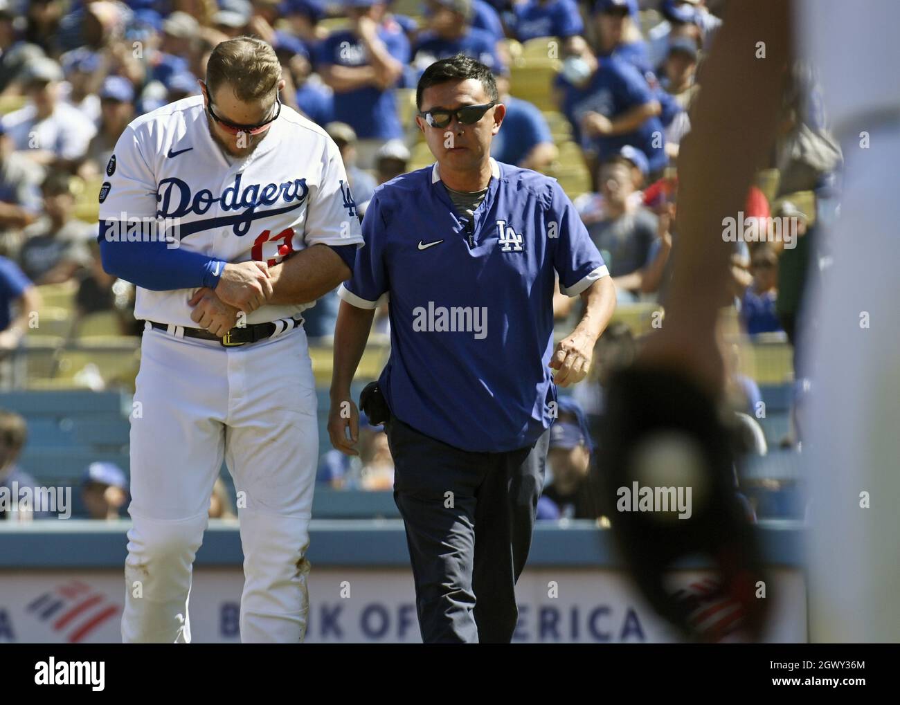 Il primo baseman Max Muncy di Los Angeles Dodgers lascia il campo con un allenatore dopo una scena spaventosa nel terzo inning contro i Milwaukee Brewers domenica 3 ottobre 2021. Il secondo baseman dei birrifici Jace Peterson ha colpito un dribbler davanti al piatto che il catcher Smith fielded pulito. Il suo tiro, tuttavia, si veicò all'interno della prima base, costringendo Muncy a tenere il braccio sinistro fuori mentre Peterson si sfondò lungo la linea. Non riusciva a tirare indietro il braccio prima che Peterson passasse attraverso di esso, piegandolo indietro e facendo cadere Muncy a terra nel dolore. Credit: UPI/Alamy Live News Foto Stock