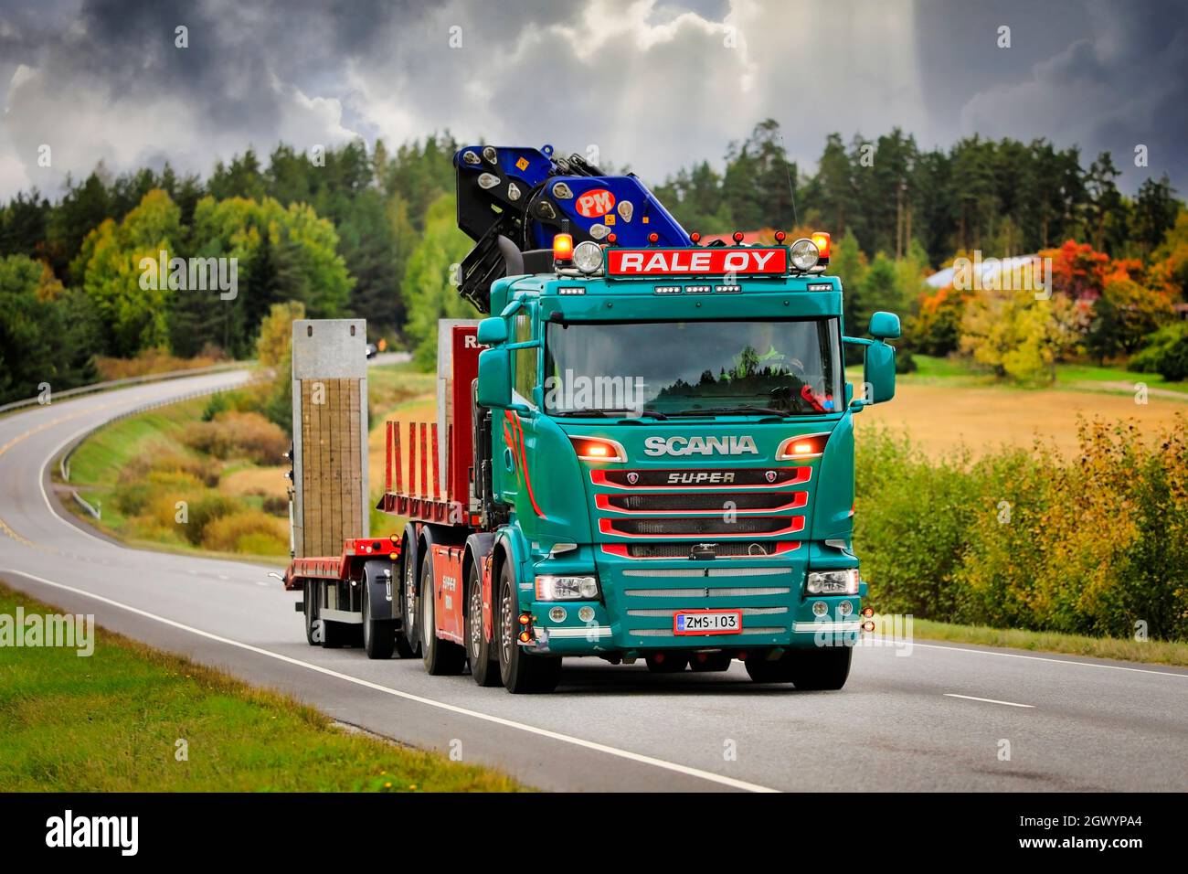 Il camion verde personalizzato Scania Rale Oy con gru montata su camion tira il rimorchio su strada 52 in una giornata nuvolosa di autunno. Salo, Finlandia. Settembre 23, 2021. Foto Stock