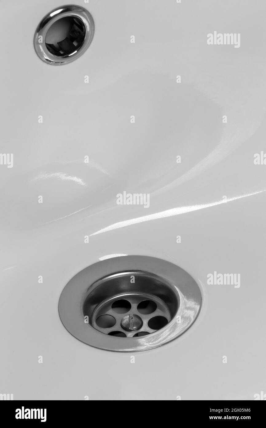 Primo piano di un foro di scarico in un lavello in ceramica bianca. Foto Stock