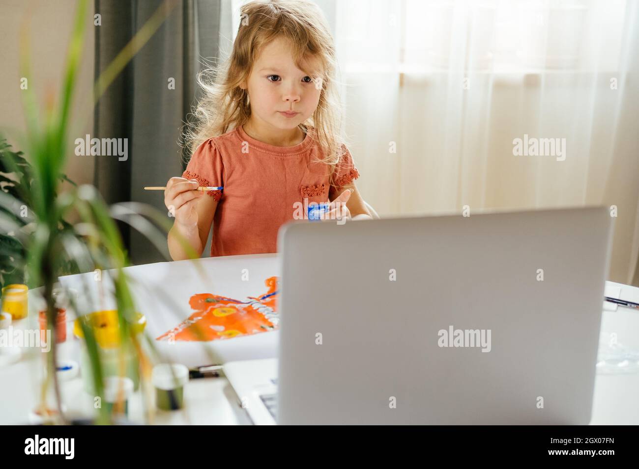 Giovane ragazza cute che spende un tempo disegnare usando le lezioni in linea sul laptop. Apprendimento a distanza, formazione online. Foto Stock