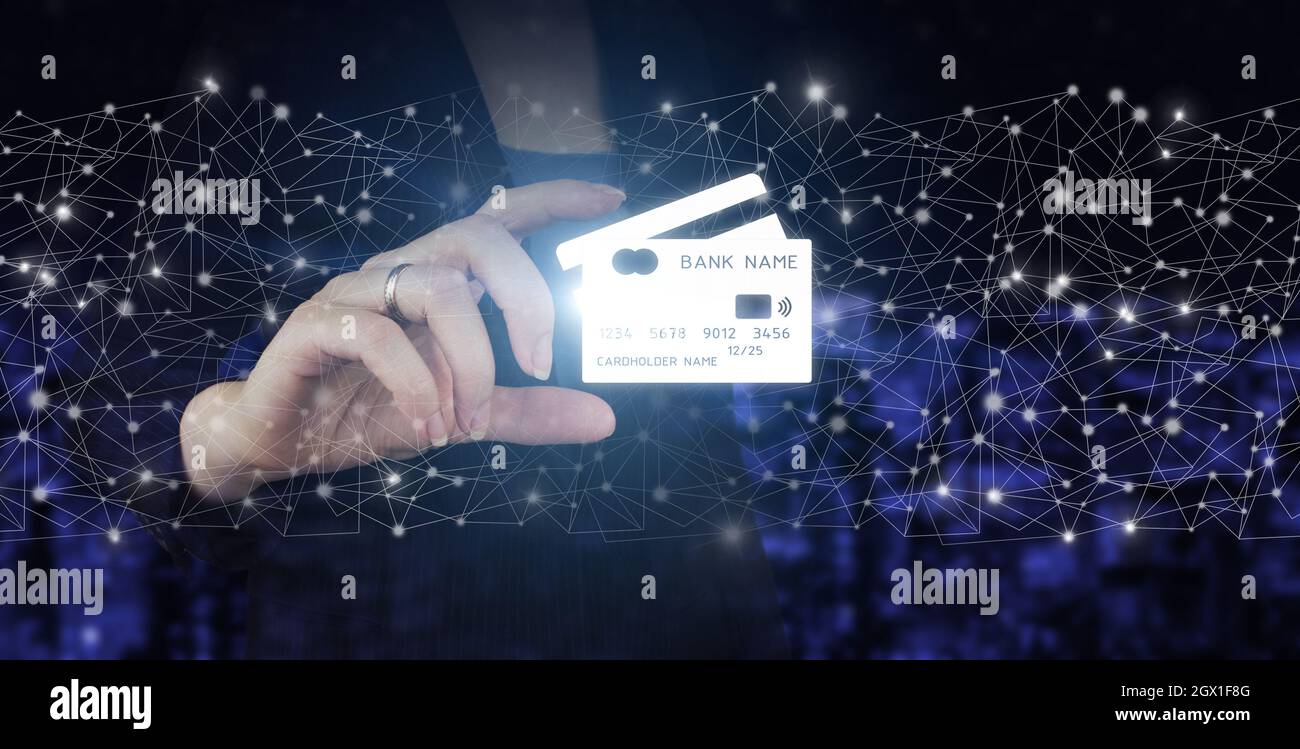Pagamento online, futuristica finanziaria e tecnologia, carta di credito sono design up. Mano tenere ologramma digitale carta di credito segno sulla città scuro sfocato backg Foto Stock
