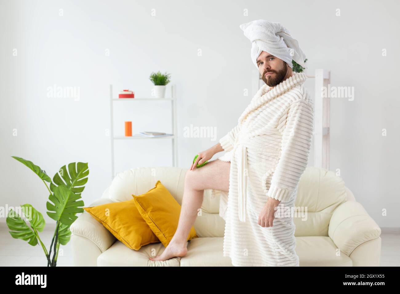 L'uomo con bacchette divertenti indossa un asciugamano turbante che si fa  un massaggio con spazzola da massaggio. Cura della pelle maschile e  concetto spa Foto stock - Alamy