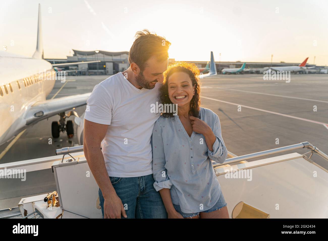 Coppia innamorata in piedi sulla scala dell'aereo prima del volo Foto Stock