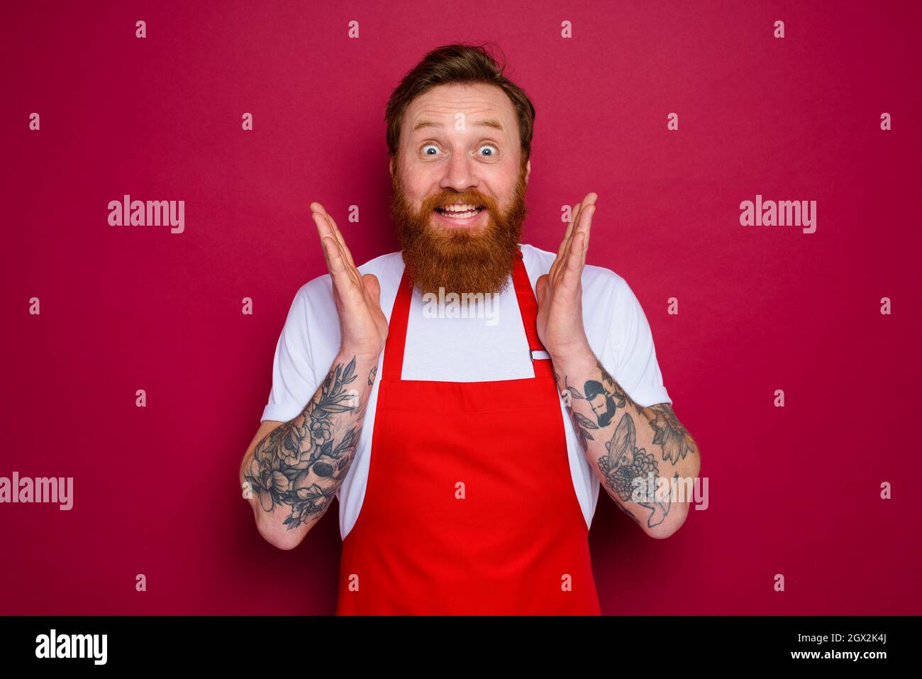 buon chef isolato con barba e grembiule rosso Foto Stock