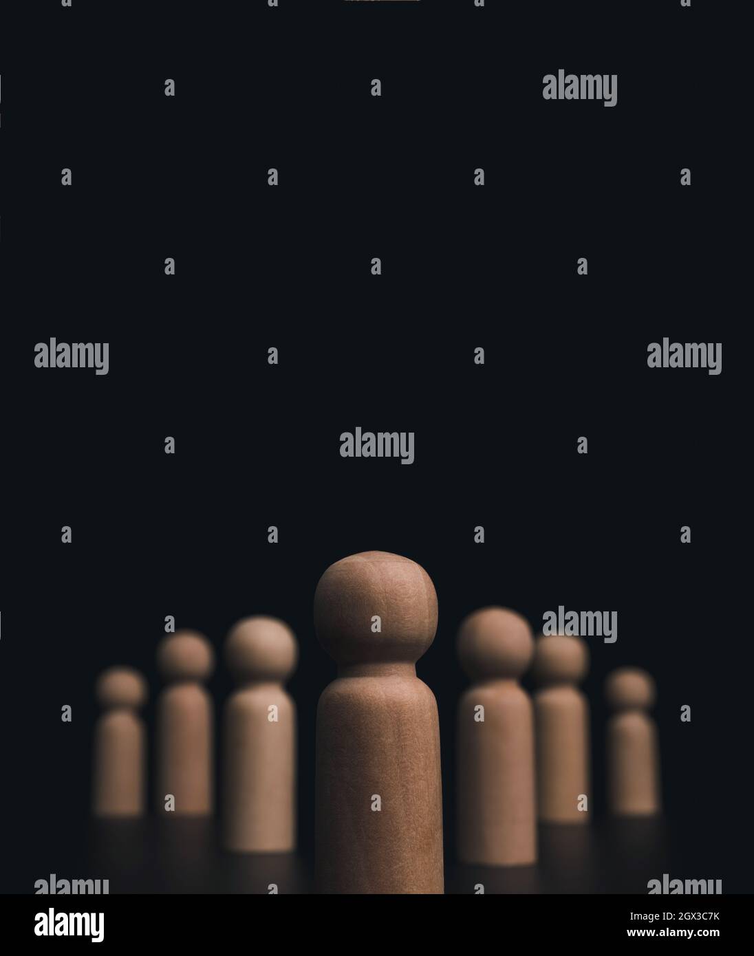 Concetto di leadership, manager, CEO, leader di mercato, Influencer, opinion leader e business leader. Leader figure in legno con seguaci su dorso scuro gr Foto Stock
