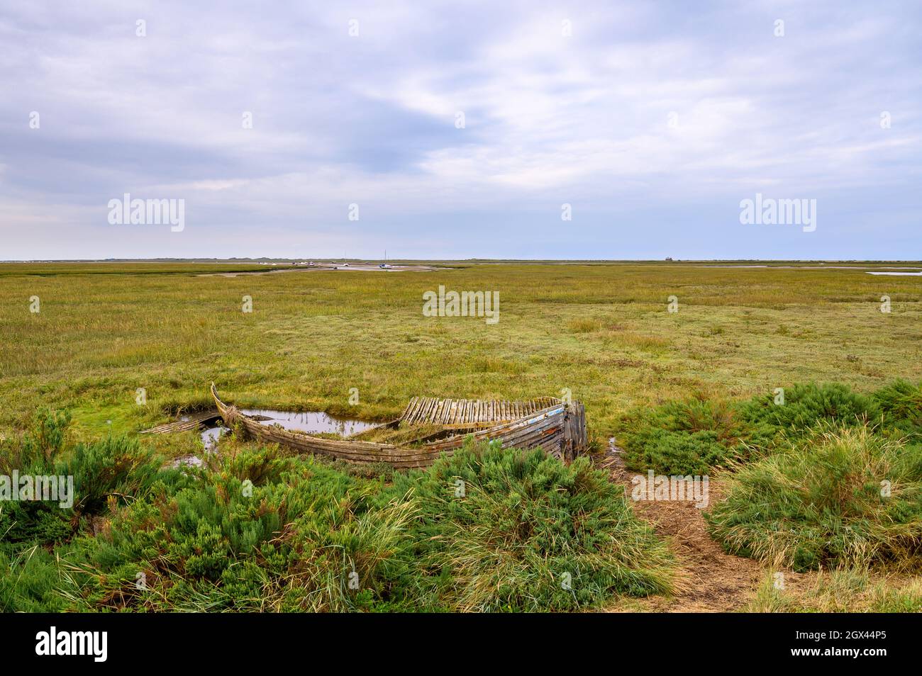 Il relitto erodente di una barca di legno posata per riposare sulla palude della Riserva Naturale Naturale di Blakeney, Norfolk, Inghilterra. Foto Stock