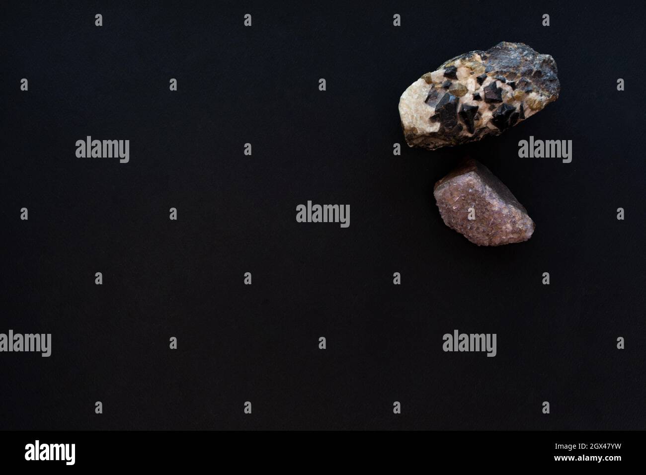 Due grandi pietre di cristallo su sfondo di carta nera. Mockup, spazio di copia. Foto Stock