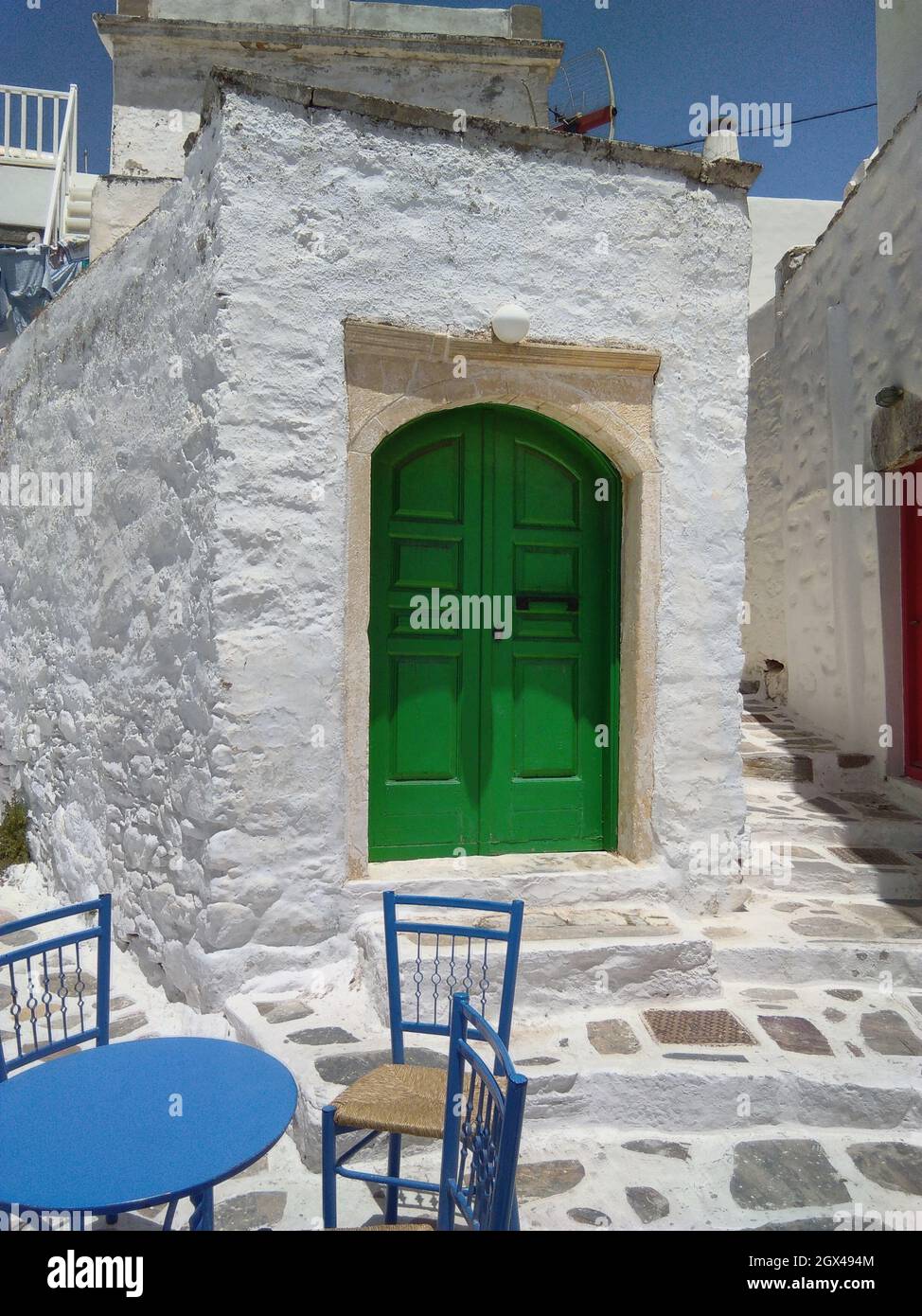 Bella isola di Amorgos, Grecia l'affascinante centro storico Una piccola, graziosa piazza con tavoli da taverna e sedie a colpo verticale Foto Stock