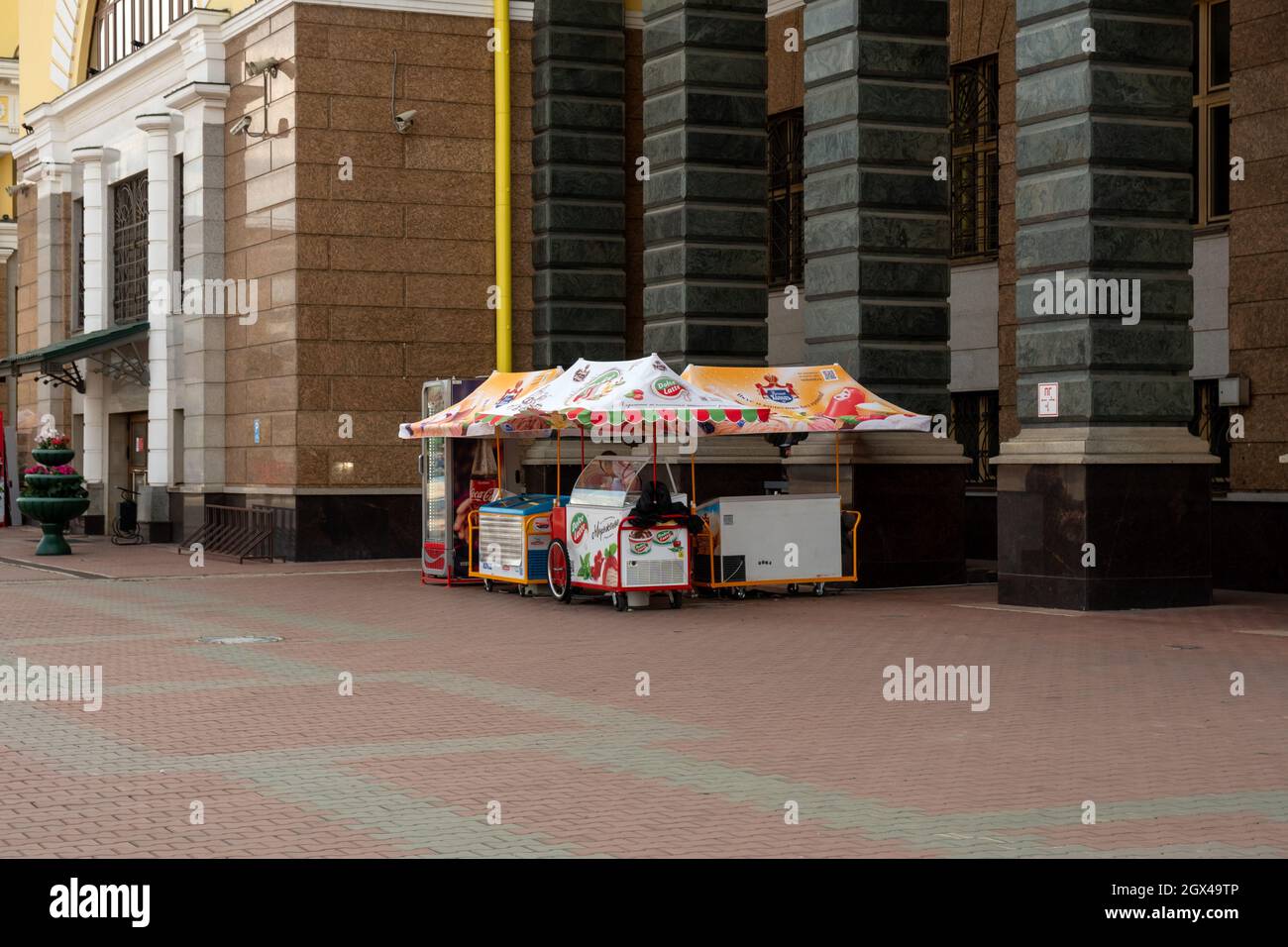 Vendita di gelato italiano da tende colorate vicino all'ingresso centrale della stazione ferroviaria principale della città. Foto Stock