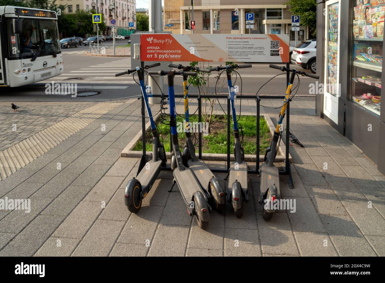 Parcheggio di scooter elettrici su Karl Marx Street, con le regole di noleggio attraverso l'applicazione in russo. Foto Stock