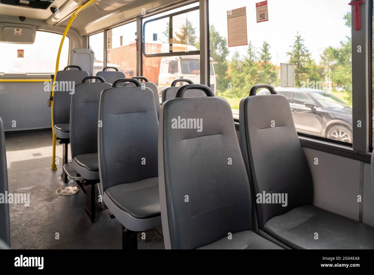 Salone di un autobus pubblico comunale con sedili in similpelle senza passeggeri. Foto Stock