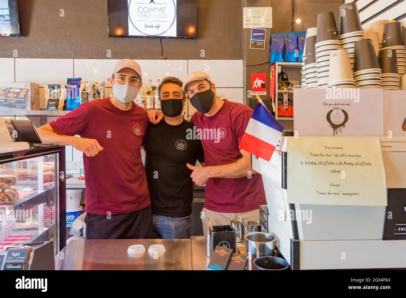 I proprietari di COOMe Chez Nous cafe e deli a Pymble, New South Wales, Australia, sorridono ma mascherati durante il Lockdown 2021 a Sydney Foto Stock