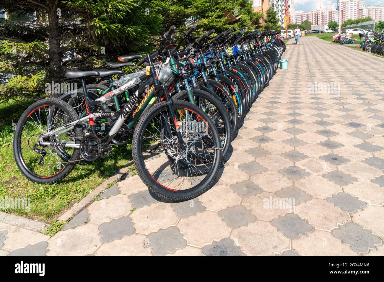 Le biciclette sono in vendita e noleggiate su un marciapiede acciottolato in una zona residenziale. Foto Stock