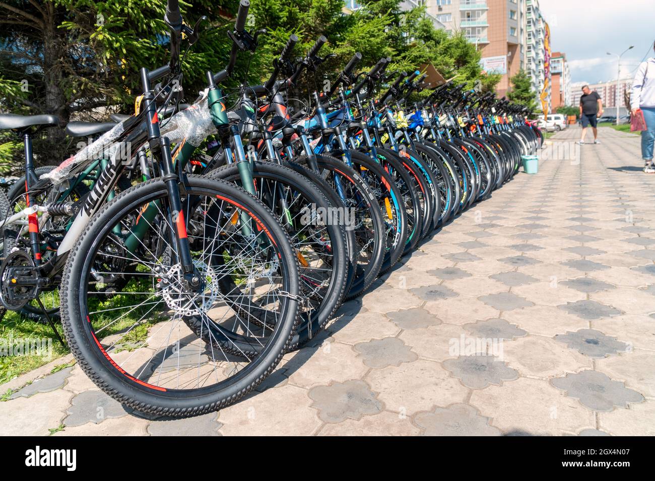 Le biciclette si trovano in fila su un marciapiede acciottolato in una zona residenziale. Foto Stock