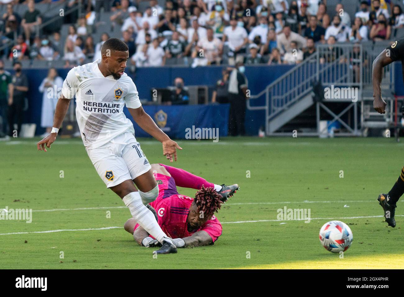Il centrocampista della Los Angeles Galaxy Samuel Grandsir (11) spara oltre il portiere del Los Angeles FC Jamal Blackman (1) per un punteggio durante una partita MLS, domenica, Oc Foto Stock