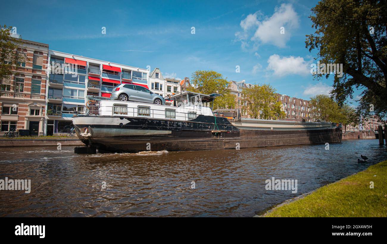 Vista di una nave che passa accanto al ponte stradale nel canale di amsterdam. Spedire sotto il ponte aperto sul canale. Foto Stock