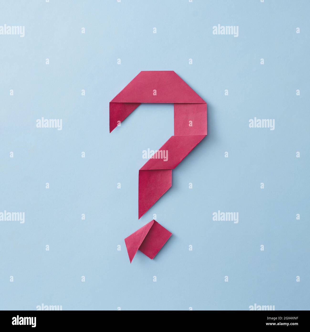 Punto interrogativo rosso origami con pieghe ordinatamente su sfondo blu per temi concettuali Foto Stock