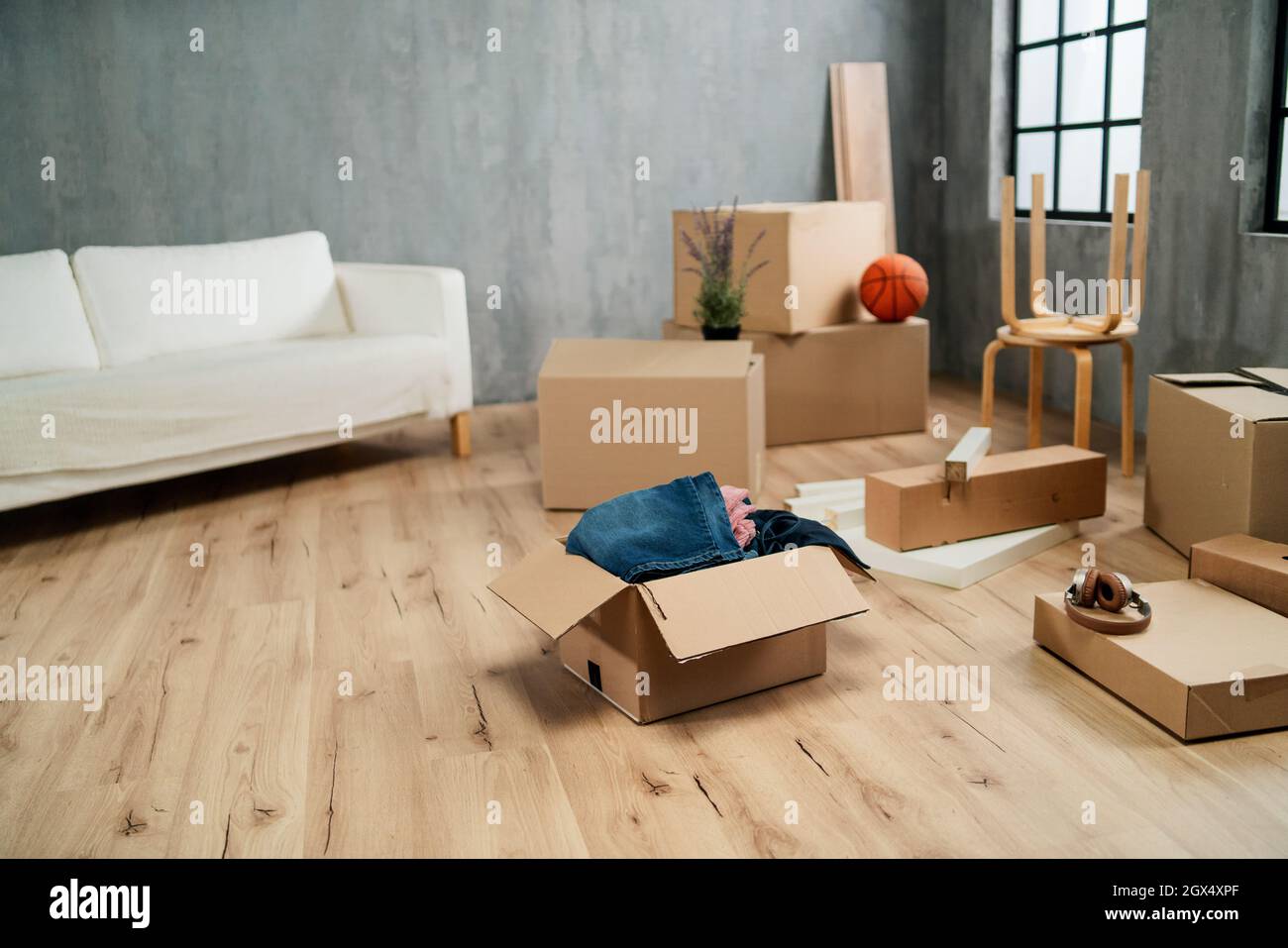 Soggiorno vuoto con scatole di cartone già imballato, concetto di casa in movimento. Foto Stock