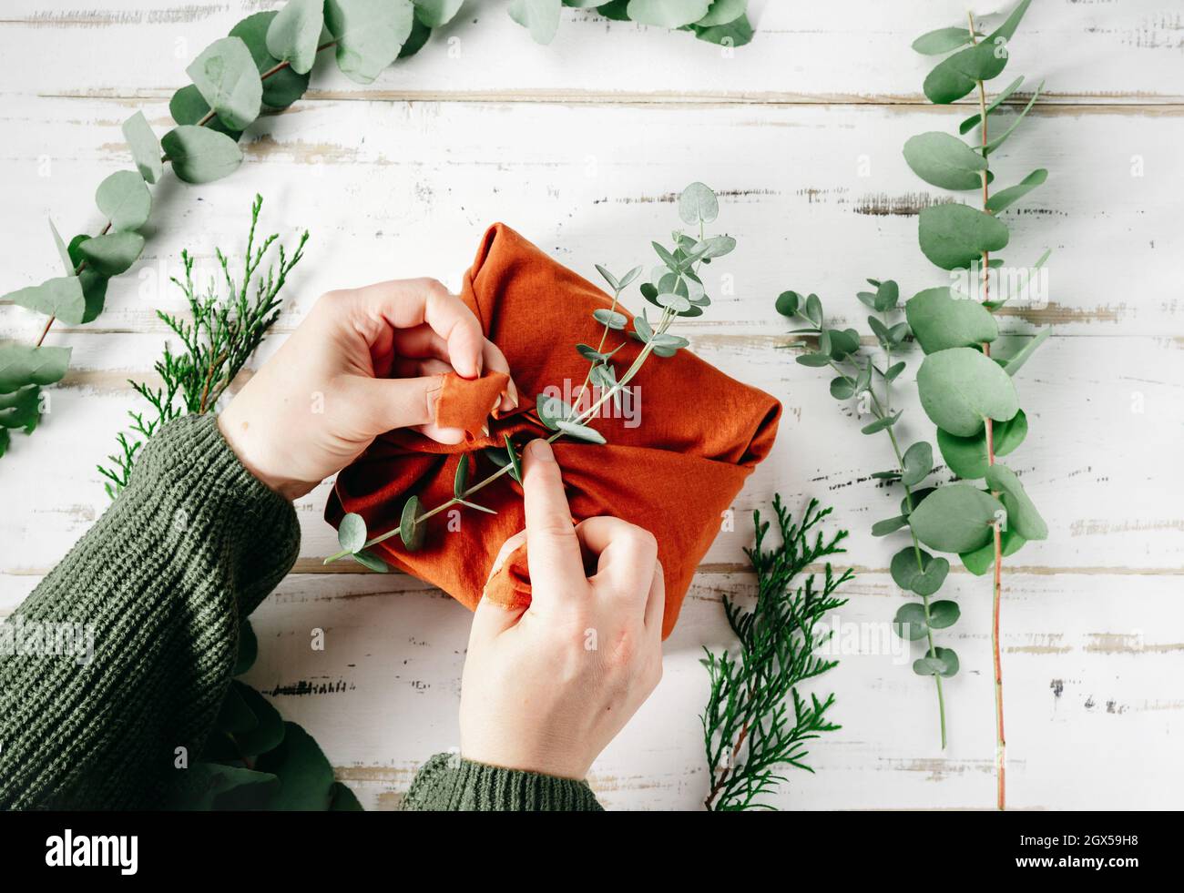 Confezionare un regalo in un tessuto ecologico riutilizzabile, furoshiki Foto Stock