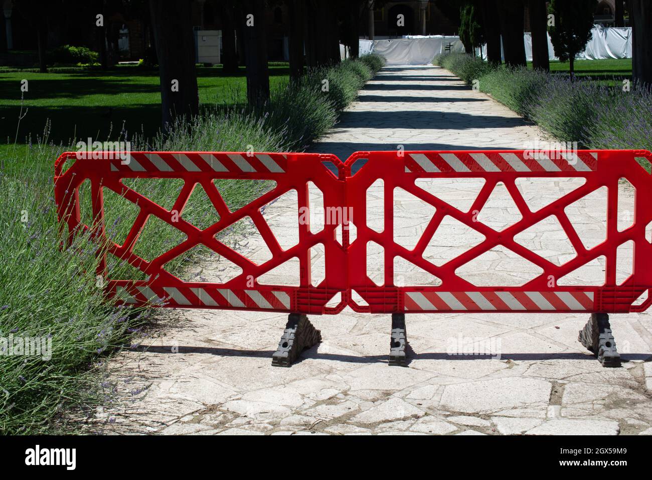 Scatto di barricate rosse in un sentiero nel parco in una giornata di sole Foto Stock