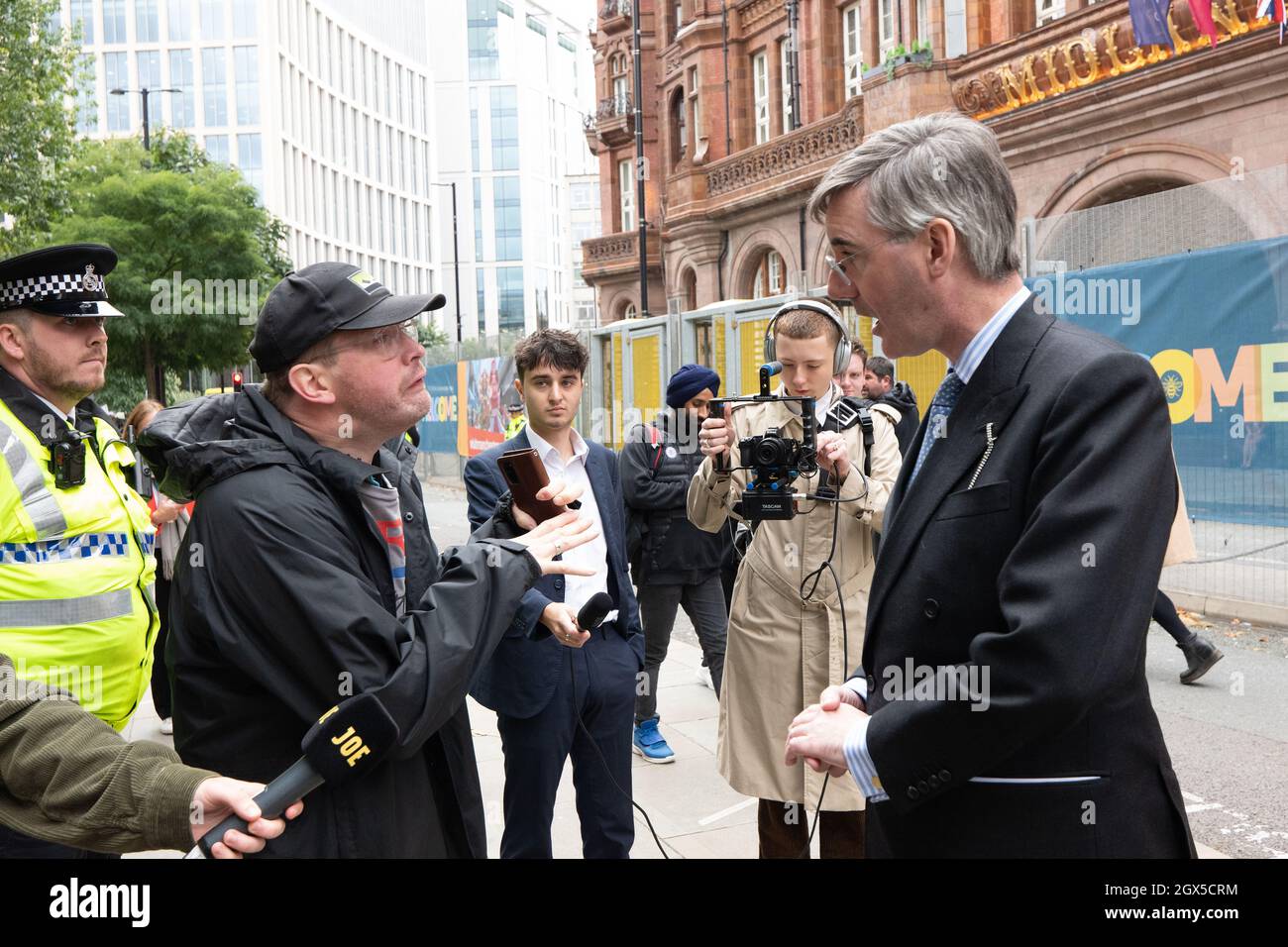 Manchester, Regno Unito. 4 ottobre 2021. Jacob Rees-Mogg ha un'errata svolta da Midland Hotel e si trova di fronte a manifestanti anti del governo, dove è consegnato e accetta una copia del nuovo statista. Manchester St Peters Sq. Manchester UK. Si è impegnato in una discussione con il consigliere locale disabili. Dominic Hutchins. Tel: 01663 746366. Email: dominic.hutchins@disleyparishcouncil.org.uk immagine di credito garyroberts/worldwidefeatures.com credito: Gary Roberts/Alamy Live News Foto Stock