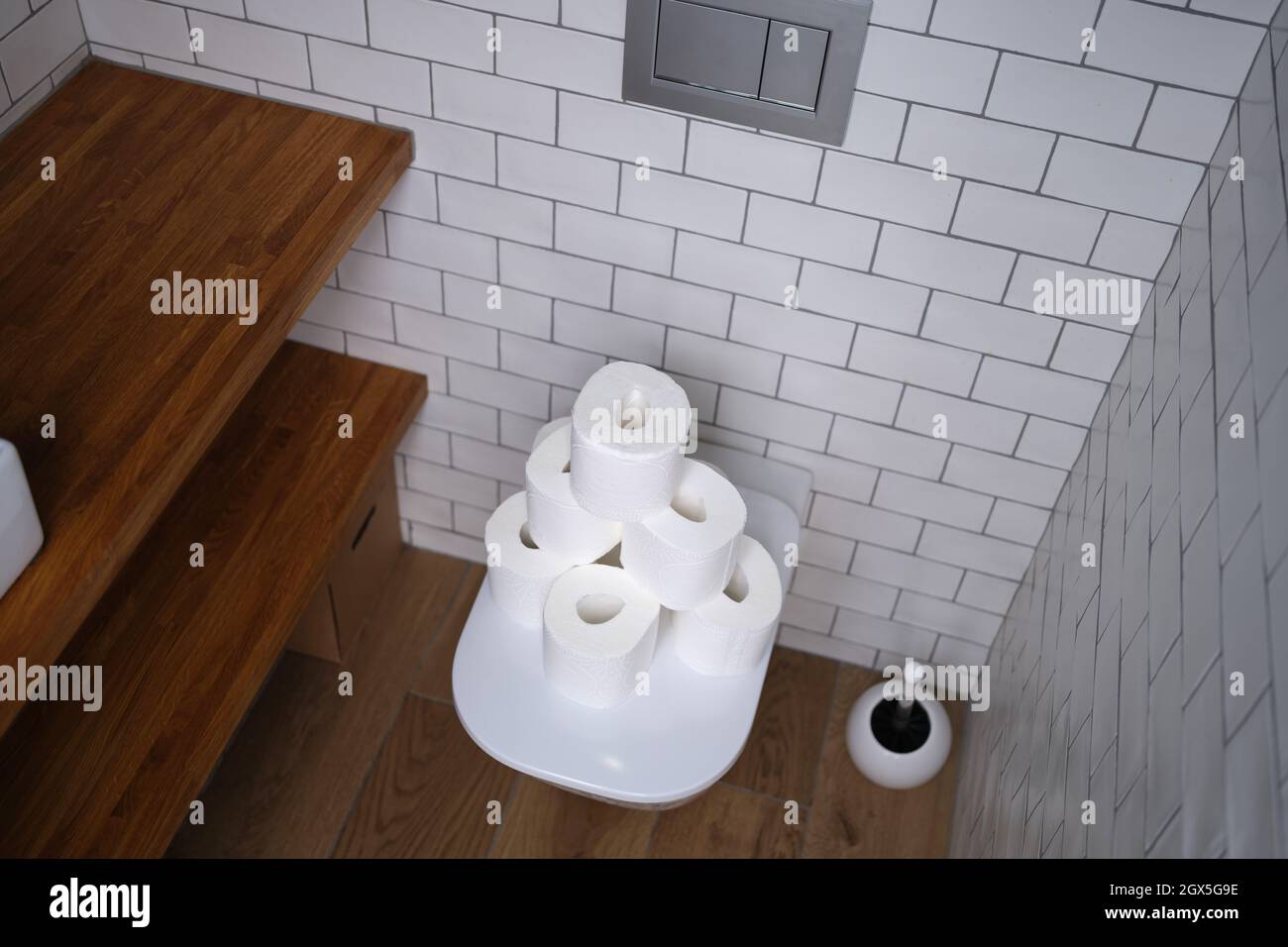 Molti rotoli di carta bianca sono sul gabinetto in stanza da bagno Foto Stock