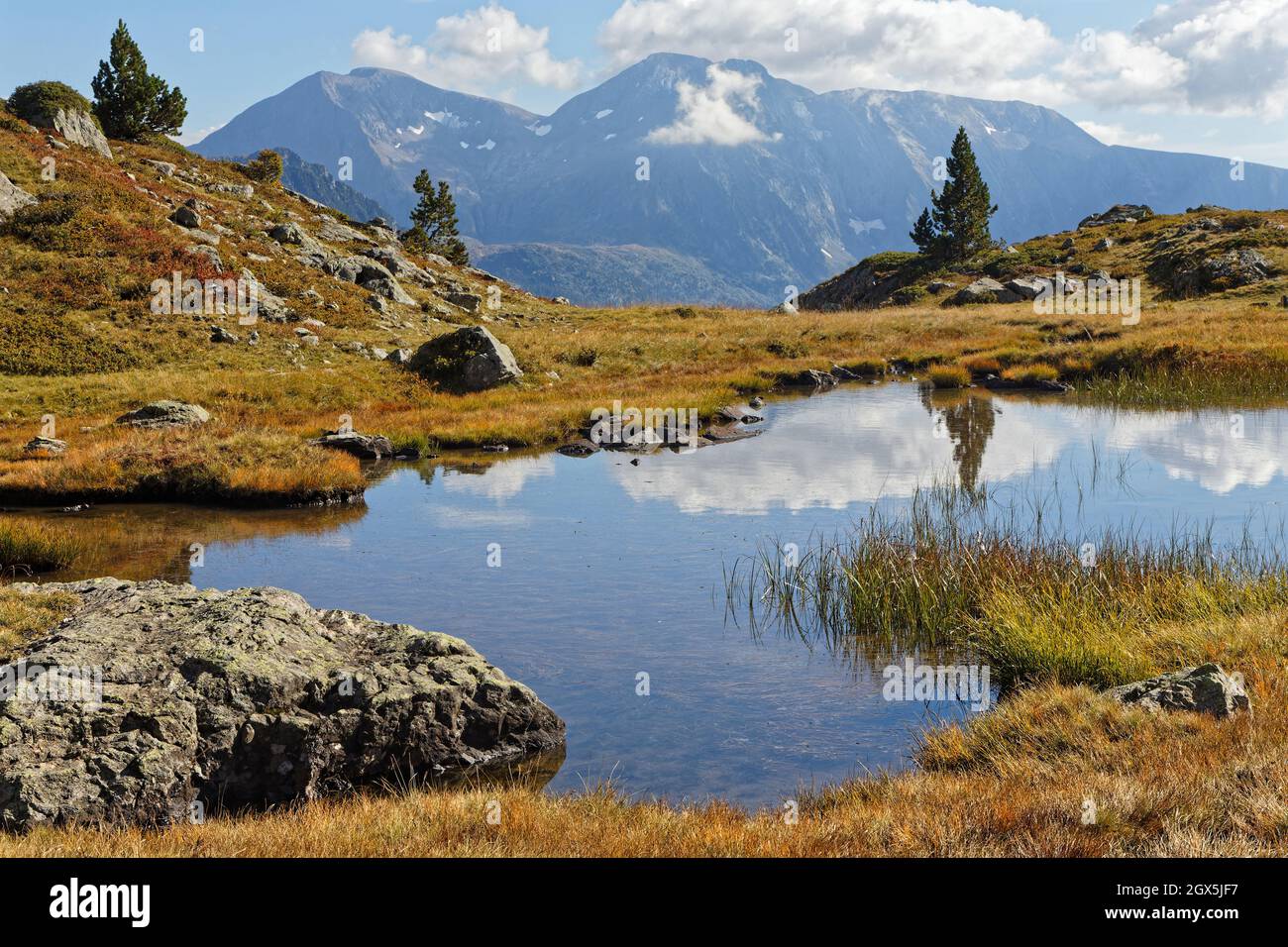 Riflessioni su un piccolo lago di montagna in Belledonne catena montuosa con cime sullo sfondo Foto Stock