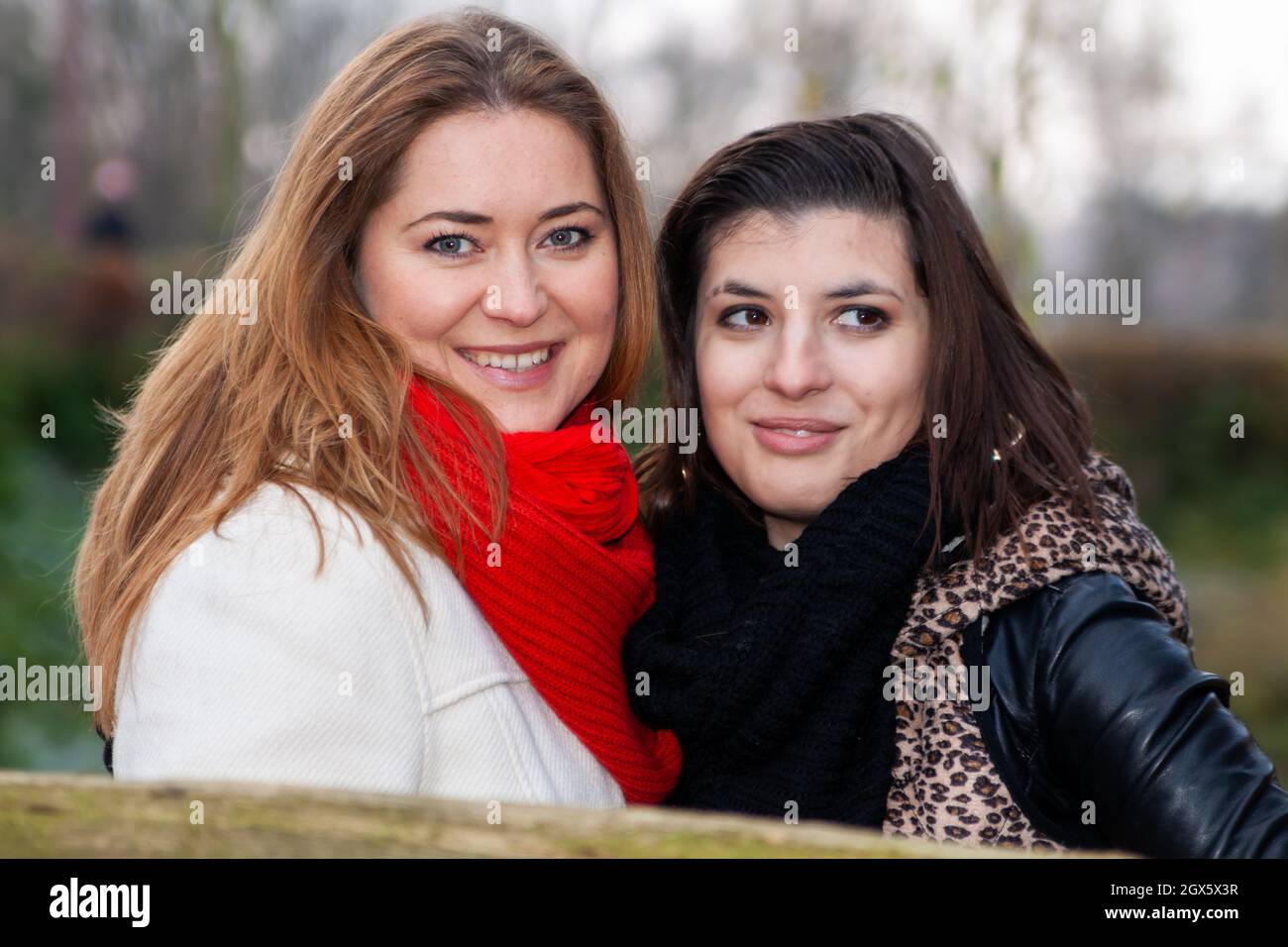 VAALS, POLONIA - 04 novembre 2010: Una donna che indossa una sciarpa rossa e un amico con una giacca in pelle in un parco. Foto Stock