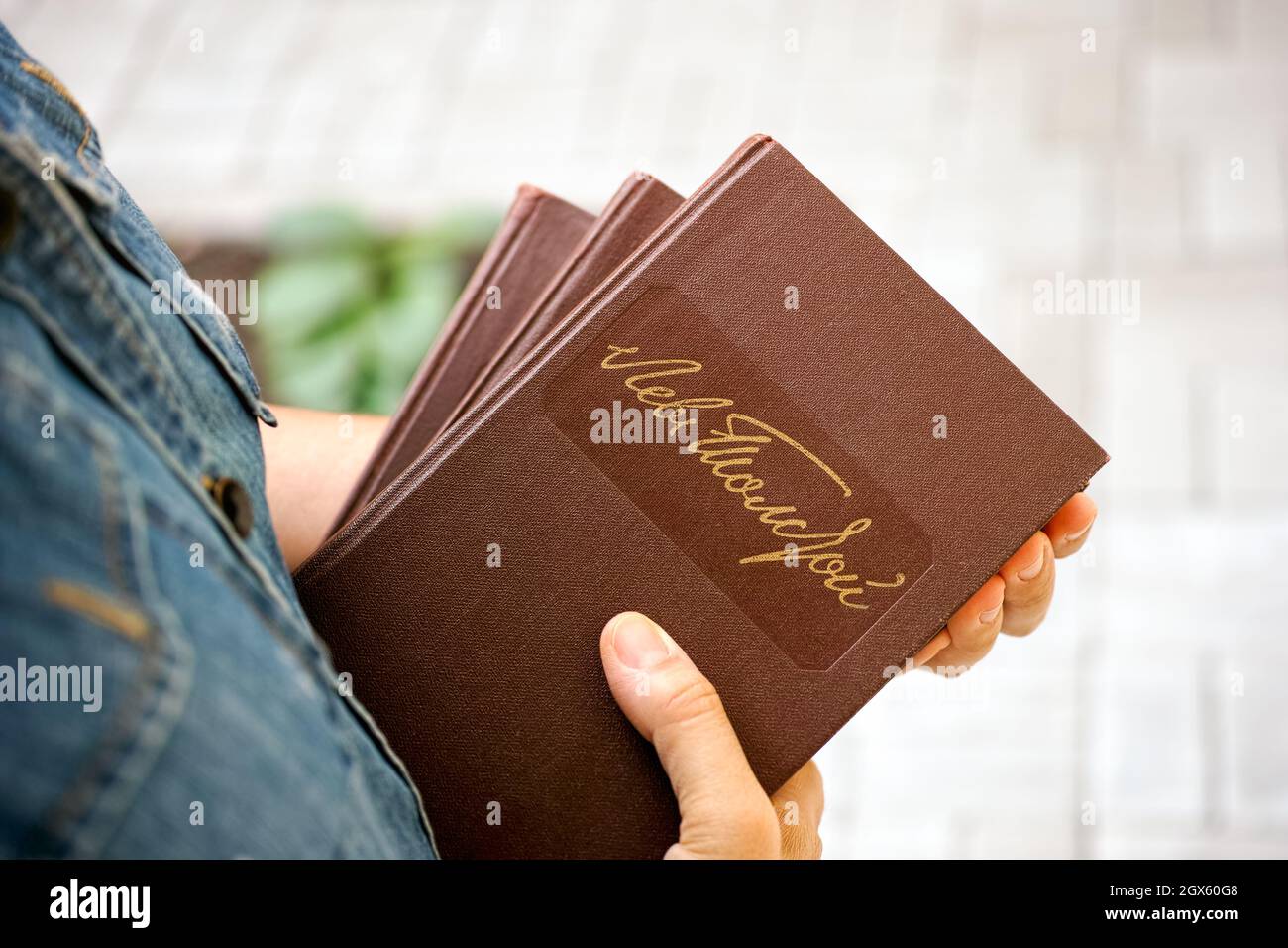 Una donna che tiene in mano i libri di Lev Tolstoy. Firma manoscritta di  Leo Tolstoy in lingua russa sulla copertina rigida del libro Foto stock -  Alamy