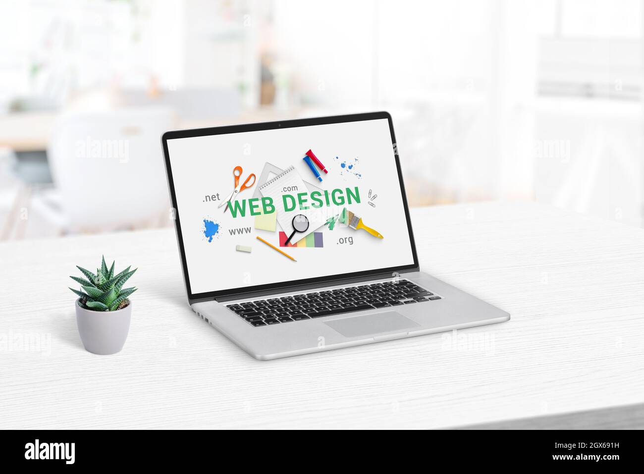 Web design studio concept page su display laptop. Pulire la scrivania dell'ufficio con lo stabilimento accanto Foto Stock