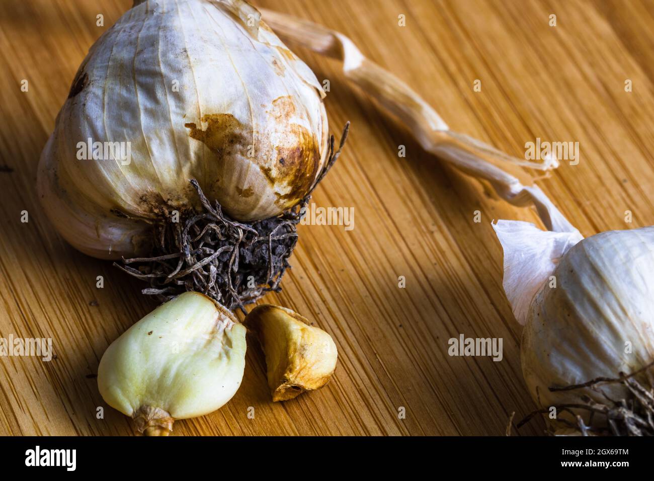 Macro colpo di aglio nel suo guscio su un tavolo di legno Foto Stock