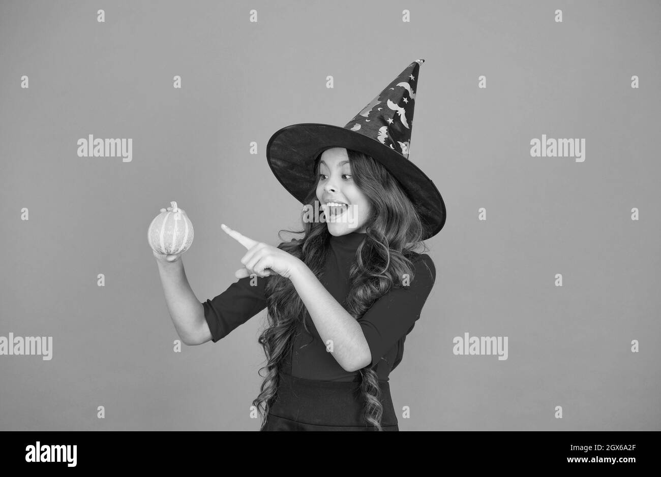 guardate quello. capretto indossa cappello di strega. bambino con la zucca piccola. la ragazza teen ha lungo capelli ricci indossare abito per festa festa. vacanze di stagione di autunno Foto Stock