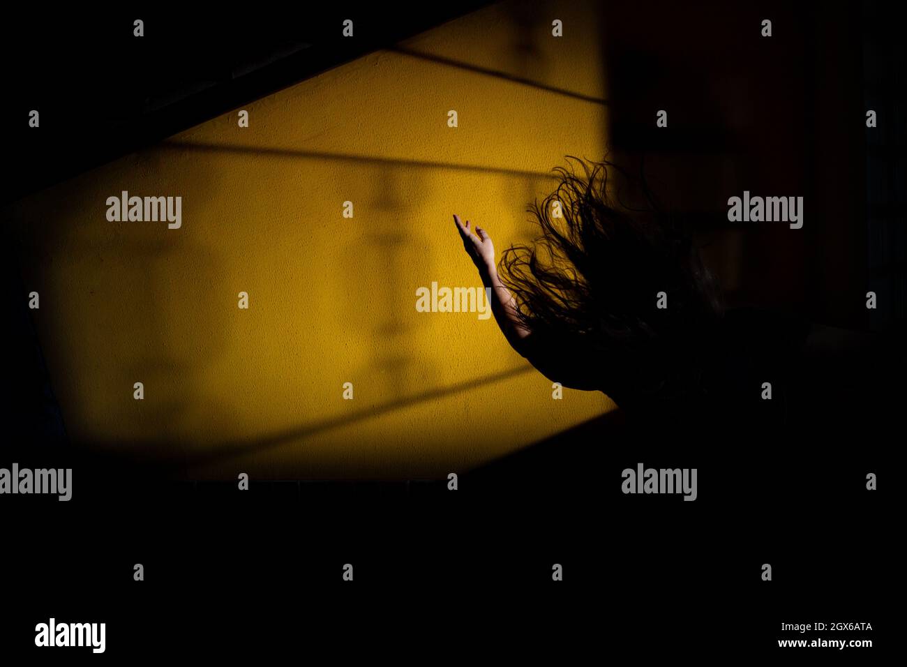 Silhouette di una donna, in disperazione, con un braccio in aria e i suoi capelli volare. Scena notte di mistero. Foto Stock