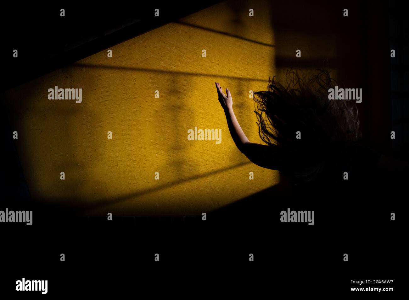 Silhouette di una donna, in disperazione, con un braccio in aria e i suoi capelli volare. Scena notte di mistero. Foto Stock