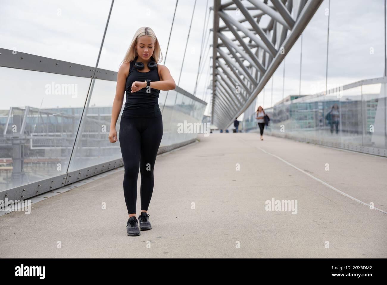 Donna che cammina controllando la frequenza cardiaca utilizzando Smartwatch dopo l'allenamento Foto Stock