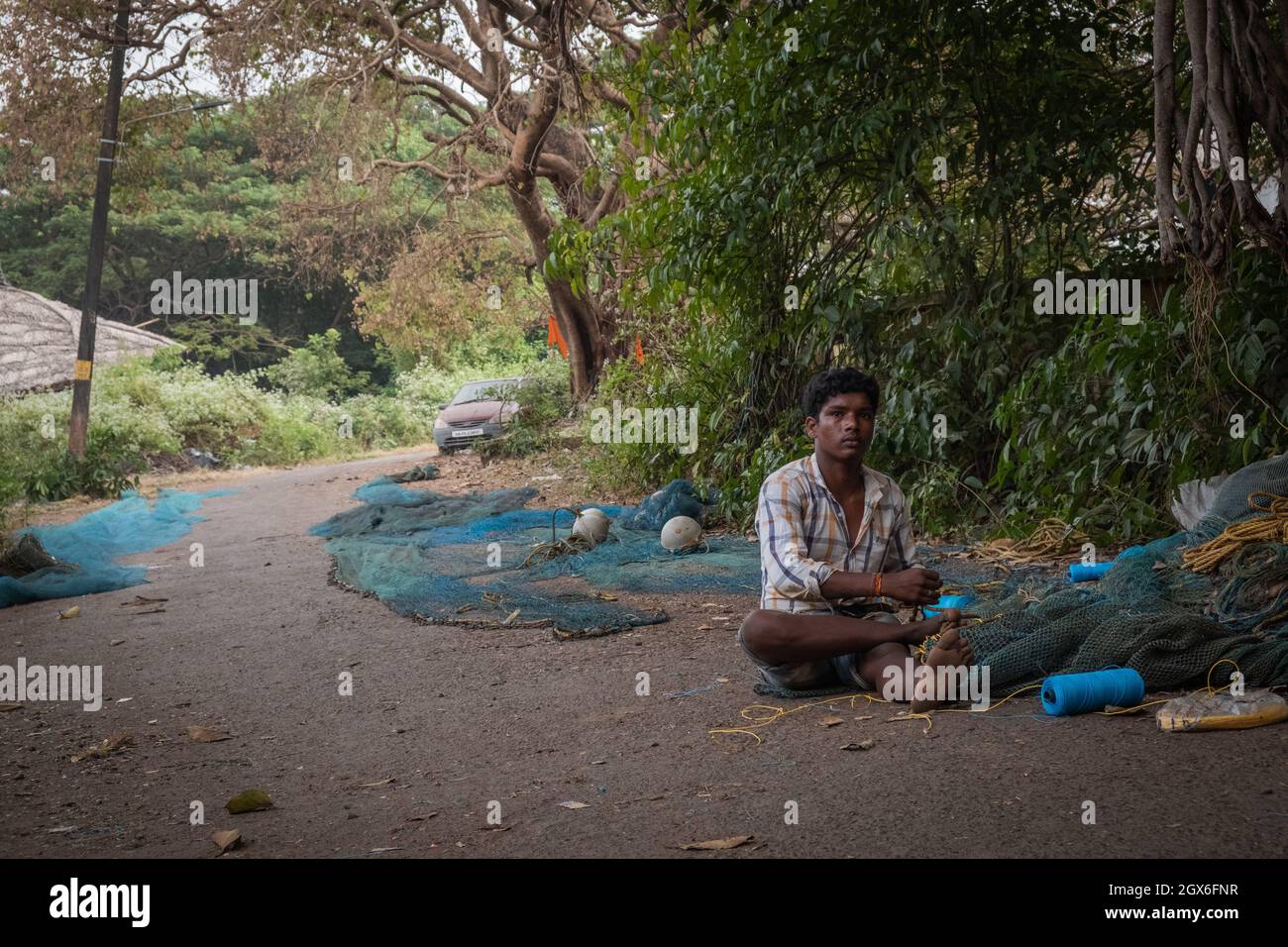 Indian Fisherman ripara la rete di pesca a Goa, India Foto Stock