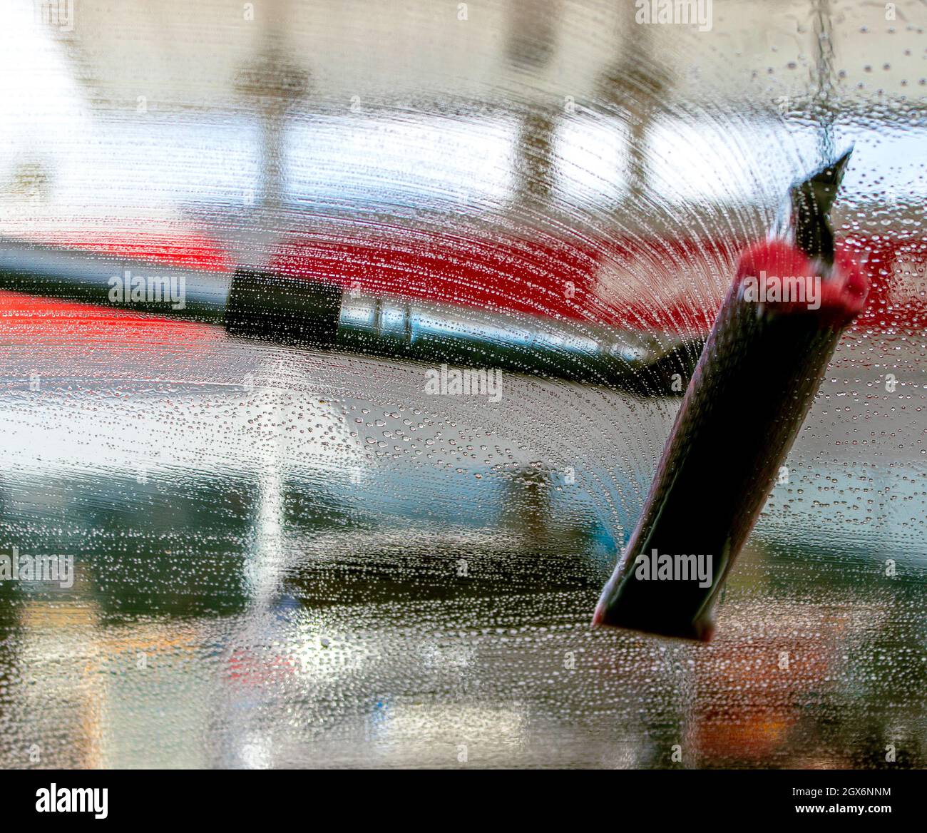 spazzolare, spazzolare il parabrezza dell'auto con acqua saponata Foto Stock