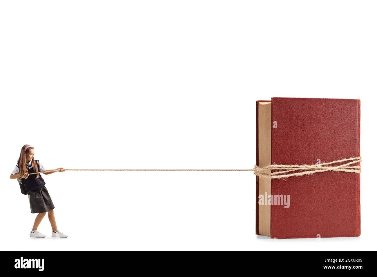 Colpo di profilo completo di una scolgirl che tira un libro con una corda isolata su sfondo bianco Foto Stock