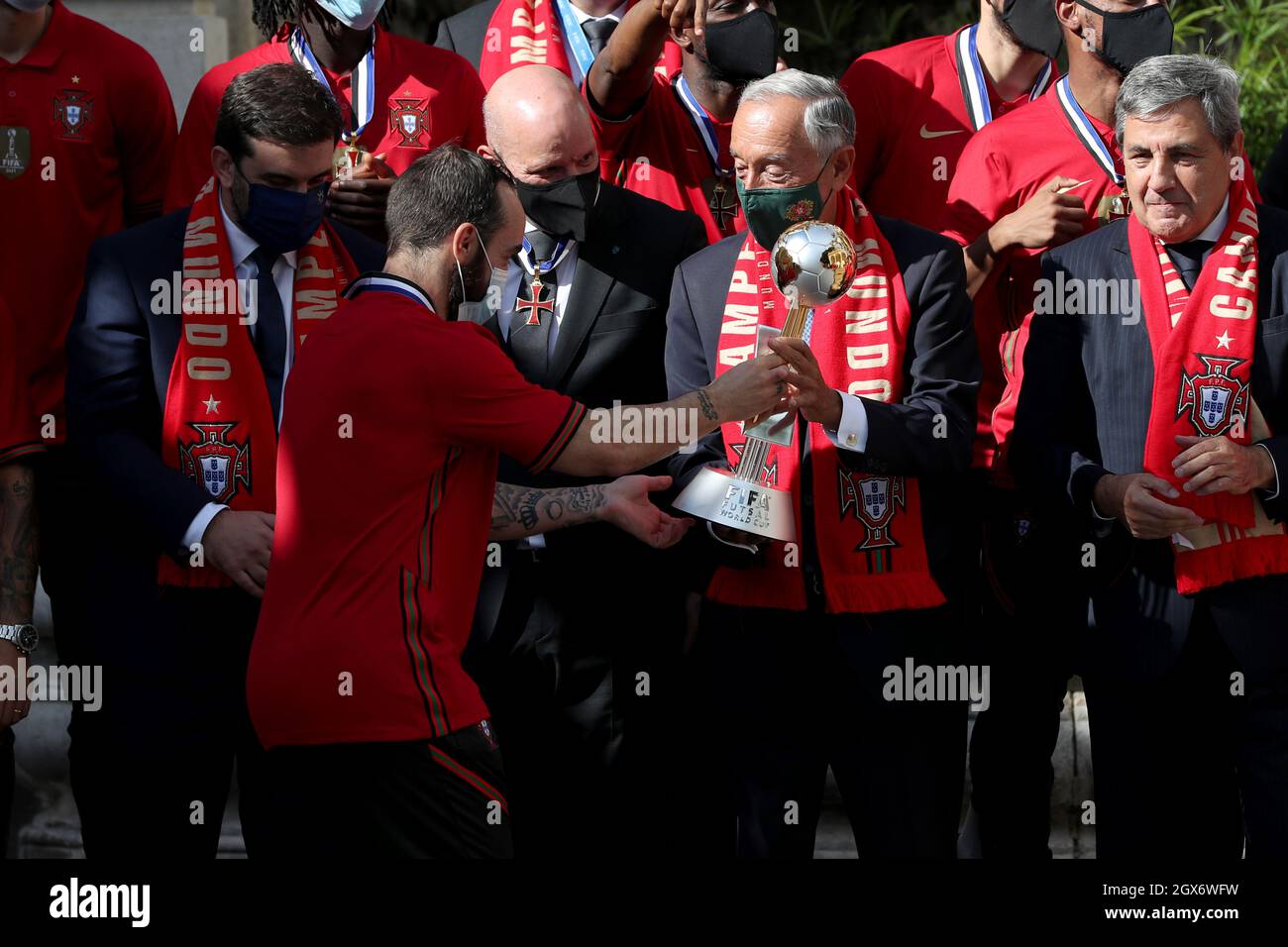 Lisbona, Portogallo. 4 ottobre 2021. Il presidente portoghese Marcelo Rebelo de Sousa (C ) riceve il trofeo della Coppa del mondo FIFA Futsal dal capitano portoghese Ricardinho (L) durante una cerimonia di benvenuto per la squadra nazionale Futsal, presso il Palazzo Belem di Lisbona, Portogallo, il 4 ottobre 2021. Il Portogallo ha vinto il trofeo FIFA Futsal World Cup 2021 dopo aver sconfitto l'Argentina (2-1) il 03 ottobre a Kaunas, Lituania. (Credit Image: © Pedro Fiuza/ZUMA Press Wire) Foto Stock