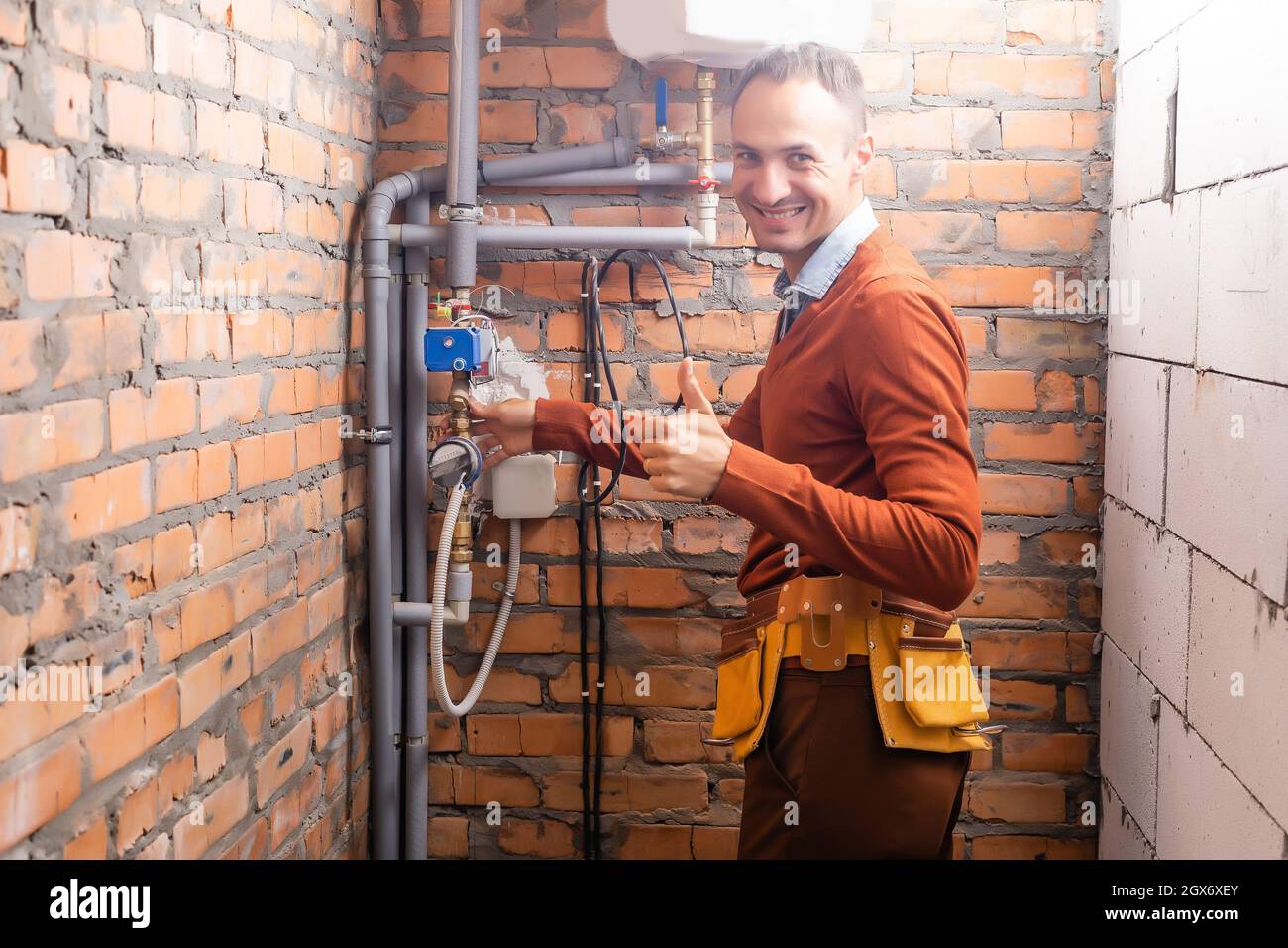 Il tecnico di assistenza ad una hot-calorifero di acqua Foto Stock