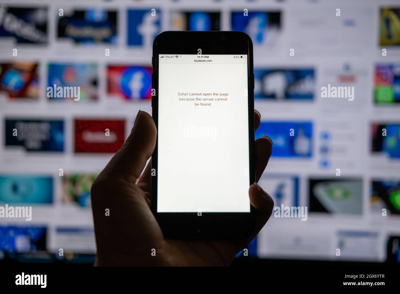 Facebook è inattivo, Instagram, WhatsApp, Messenger problemi. La mano con iphone con pagina Facebook aperta non può essere aperta sullo sfondo del logo di Facebook Foto Stock