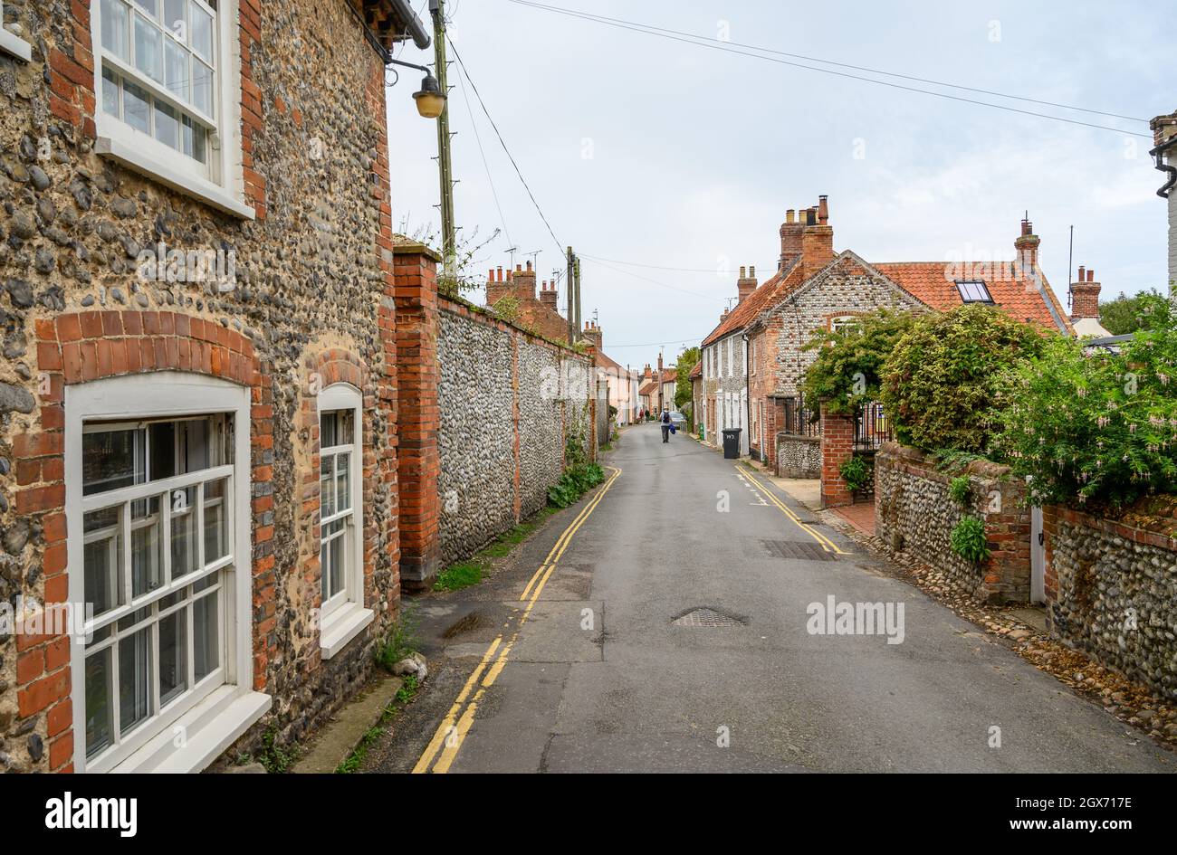 High Street nel villaggio di Blakeney è una strada affascinante con case d'epoca con facciate in pietra arenaria o pietra focaia piena di carattere, Norfolk, Inghilterra. Foto Stock