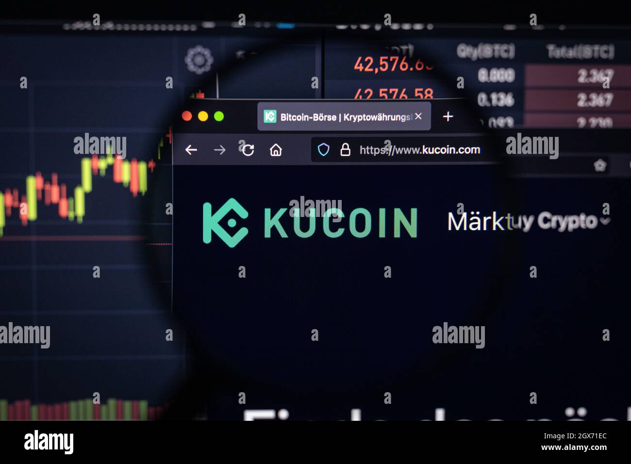 Kucoin cripto scambio logo su un sito web con blurry sviluppi del mercato azionario in background, visto su uno schermo del computer Foto Stock