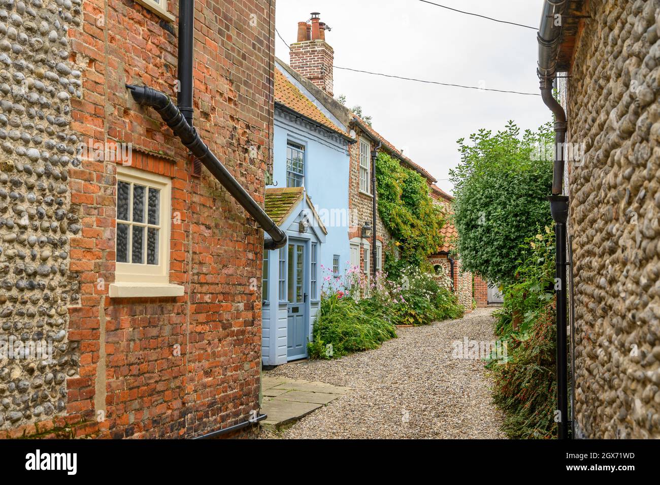 High Street nel villaggio di Blakeney è una strada affascinante con le case d'epoca con facciate in mattoni o selce renderizzate piene di carattere, Norfolk, Inghilterra. Foto Stock
