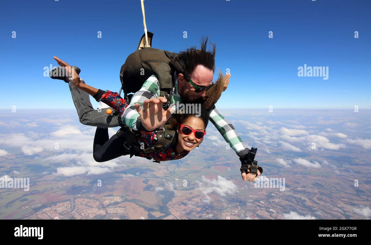 Salto in paracadute tandem. Bella donna brasiliana. Foto Stock