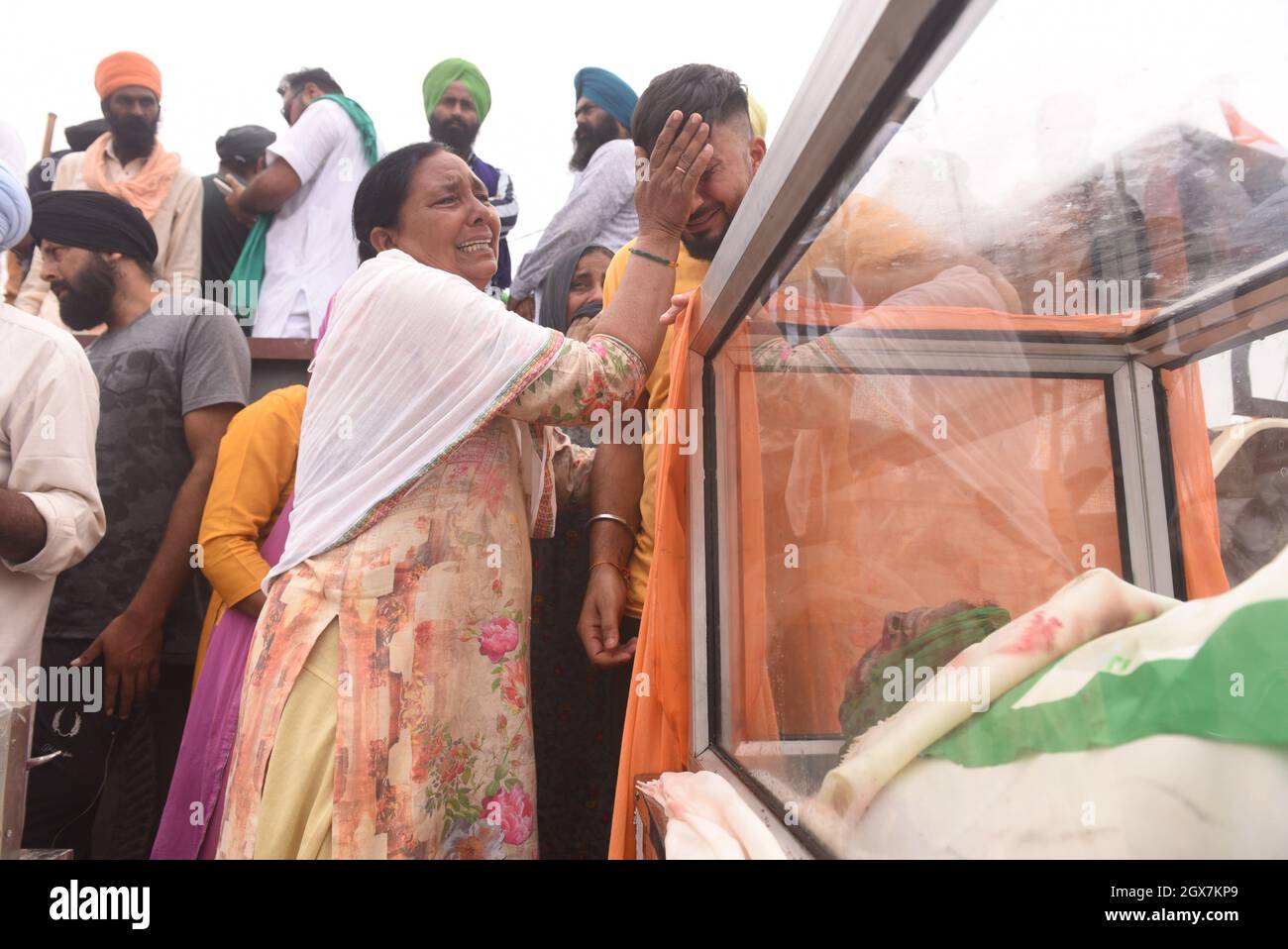 LAKHIMPUR KHERI, INDIA - 4 OTTOBRE: I membri della famiglia degli agricoltori si riuniscono per piangere la morte di quattro agricoltori sono stati uccisi a Tikunia il 4 ottobre 2021 a Lakhimpur Kheri, India. Il governo dell'Utttar Pradesh lunedì ha sospeso i servizi Internet e ha impedito ai politici di entrare in Tikonia a Lakhimpur Kheri, dove otto persone sono state uccise in un'escalation mortale di una manifestazione di un anno contro le controverse leggi agricole. I manifestanti hanno sostenuto che un'auto del convoglio del figlio del ministro dell'Unione Ajay Mishra Teni ha corso sui manifestanti. I quattro lavoratori del BJP sono stati picchiati dal prote Foto Stock