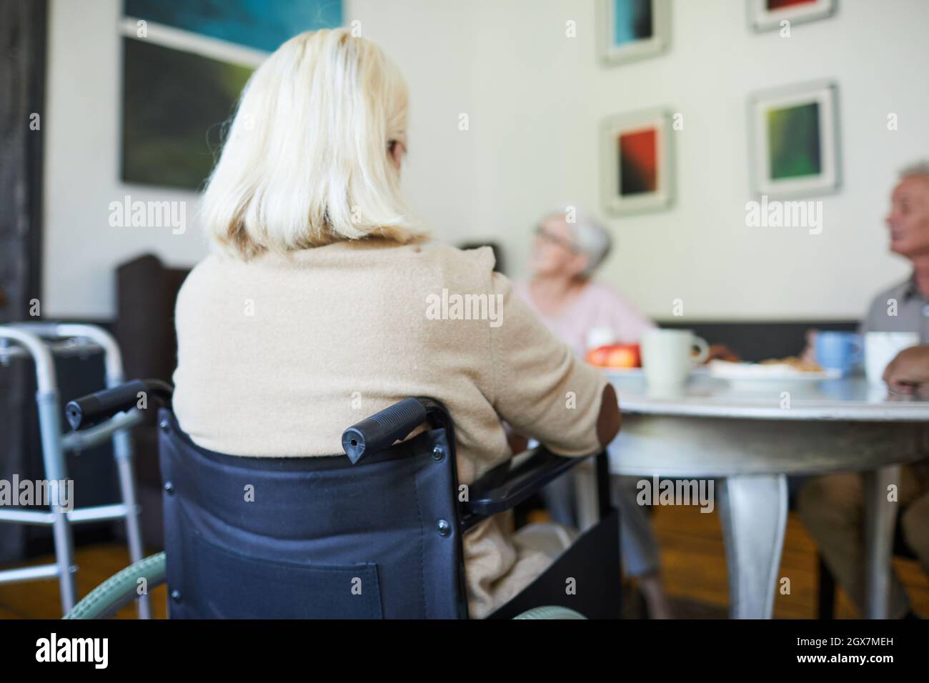Vista posteriore a capelli bianchi donna anziana seduta in sedia a rotelle a casa di cura, spazio copia Foto Stock