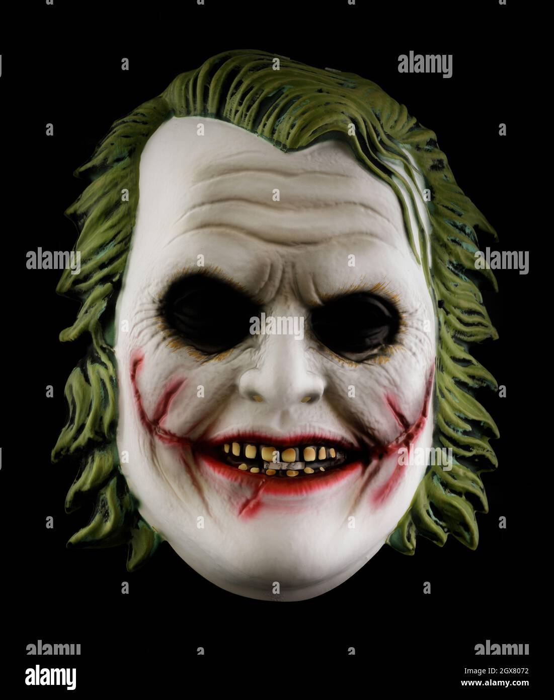La maschera di Joker del Cavaliere Oscuro è isolata su sfondo nero Foto Stock