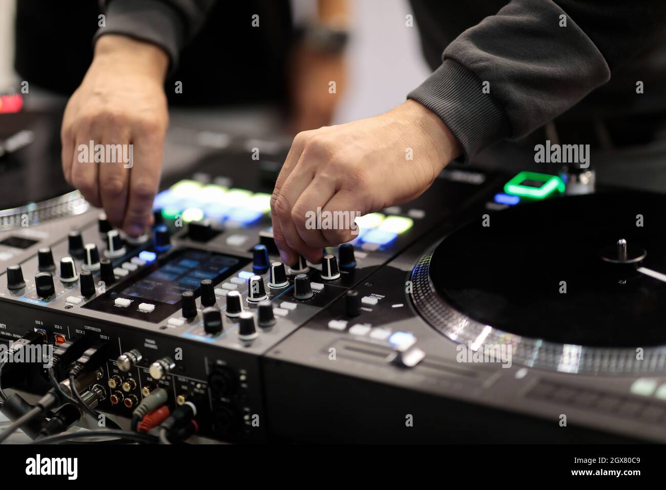 DJ mixa le tracce su un controller MIDI professionale. Messa a fuoco selettiva. Foto Stock
