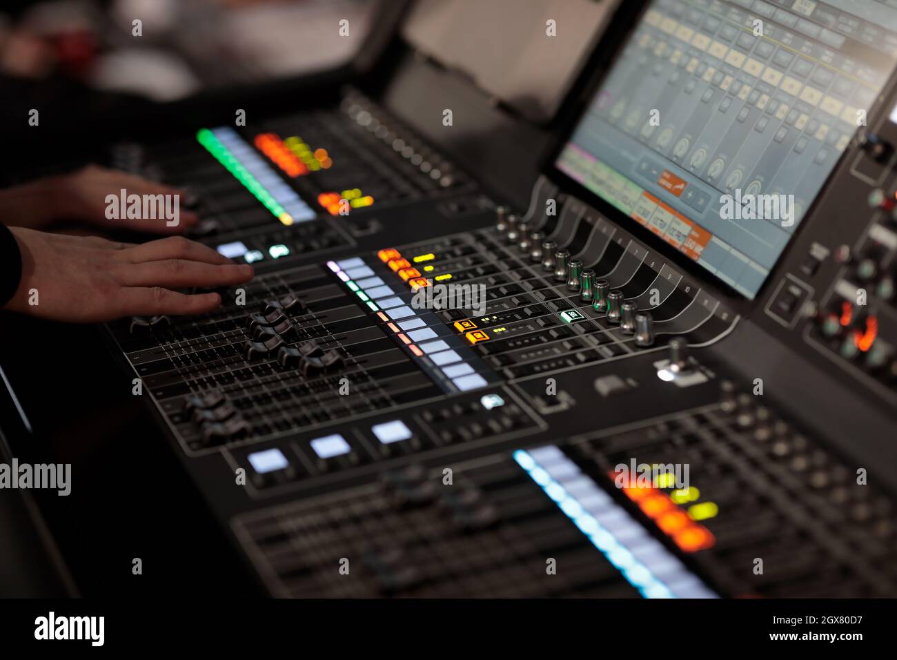 Ingegnere del suono al lavoro con la console di mixaggio digitale durante un evento dal vivo. Messa a fuoco selettiva. Foto Stock